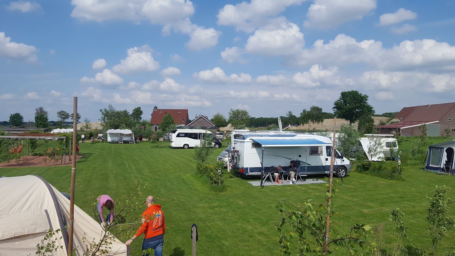 Campers en caravans aan de rand van het veld